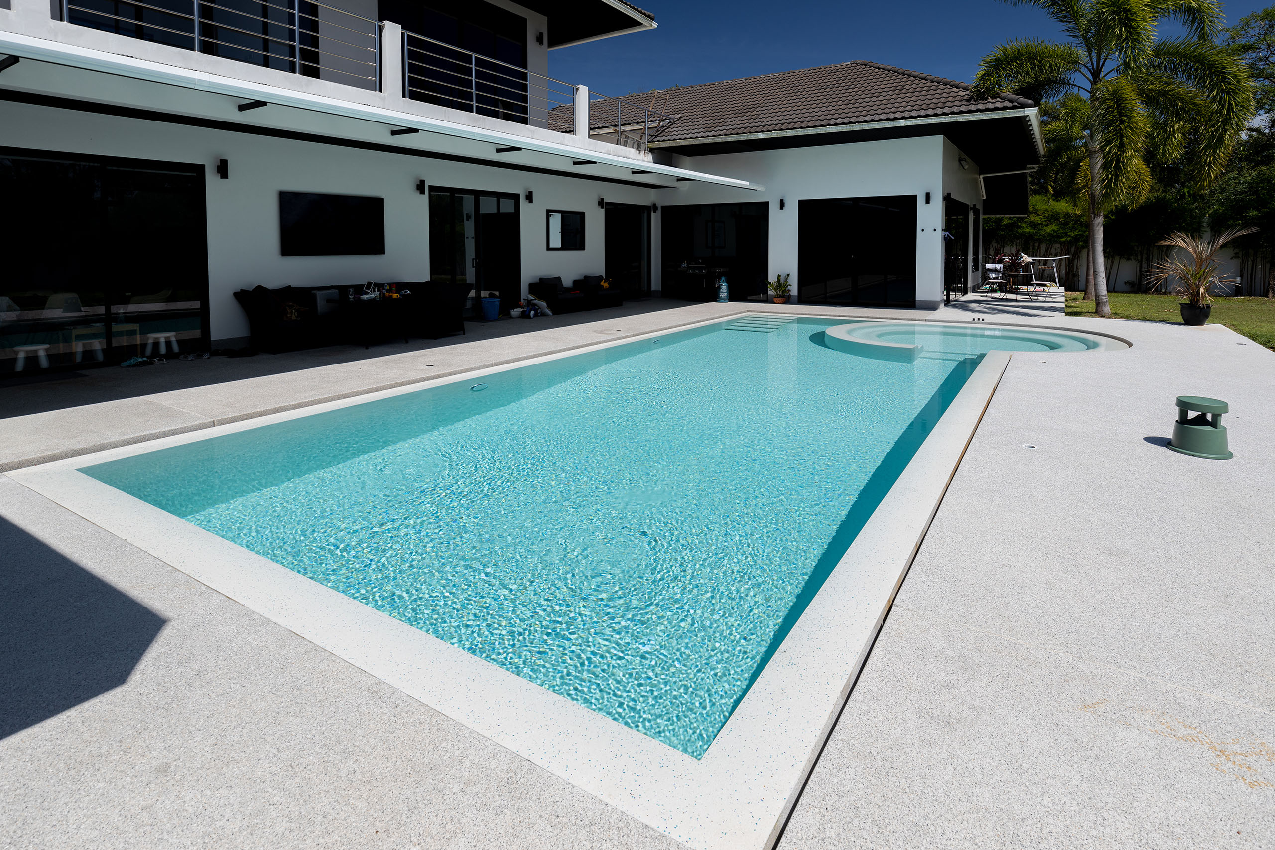 Outdoor luxury pool with sun loungers and tropical garden